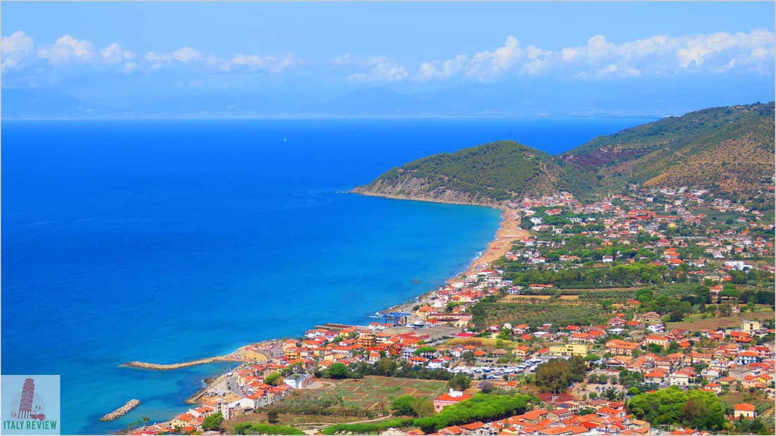 Aerial view of a coastal town with vibrant blue sea.